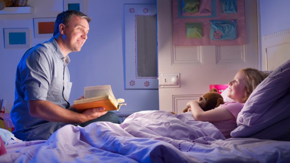 picture of dad reading bedtime story to daughter