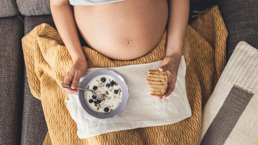 picture of pregnant woman eating bread and yoghurt