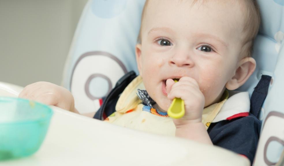 picture of a baby in a highchair eating