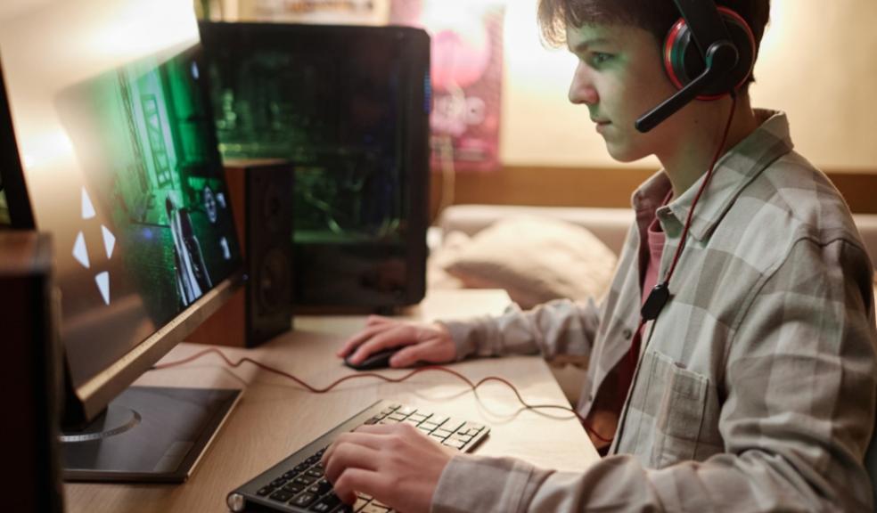 picture of a boy online gaming on a desktop computer in his bedroom