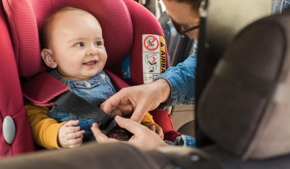 a happy baby being strapped into a car seat in a car by their parent picture of a happy baby being strapped into a car seat in a car by their parent