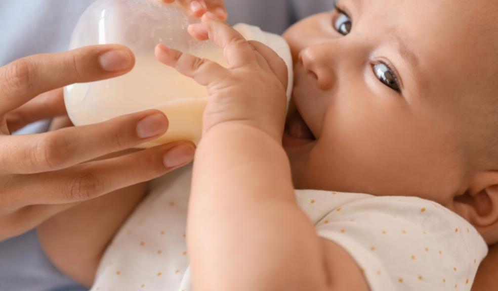 picture of a happy baby drinking a bottle of milk that has been prepared quickly