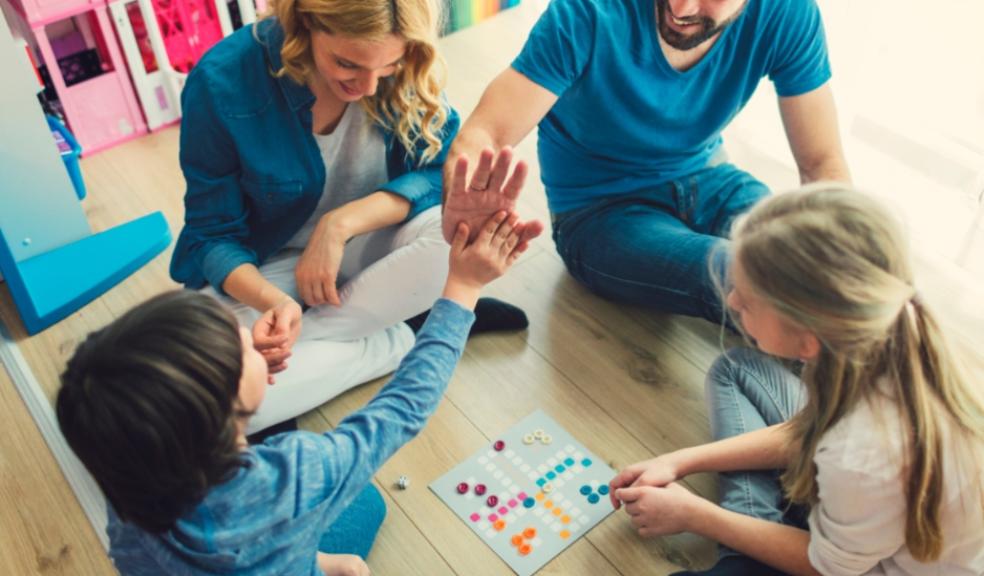 picture of a happy family enjoying plating a board game together at home
