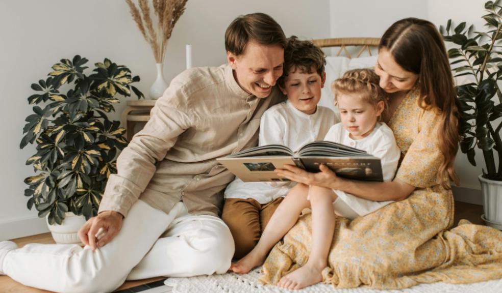 a happy family looking at a book as part of a calm evening routine picture of a happy family looking at a book as part of a calm evening routine