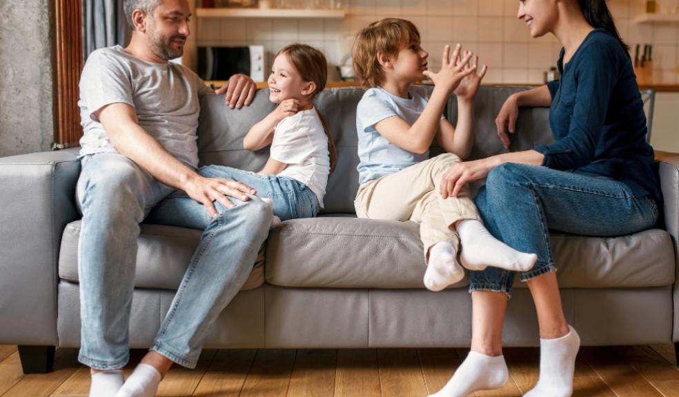 picture of a happy family sat on a sofa talking to eachother building good communication skills