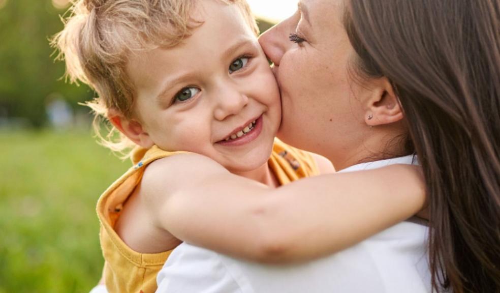 a mum kissing her happy child on the cheek picture of a mum kissing her happy child on the cheek