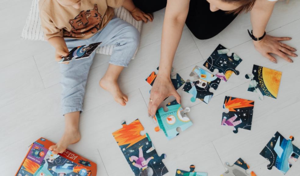 a parent and child doing a puzzle to promote problem solving skills picture of a parent and child doing a puzzle to promote problem solving skills