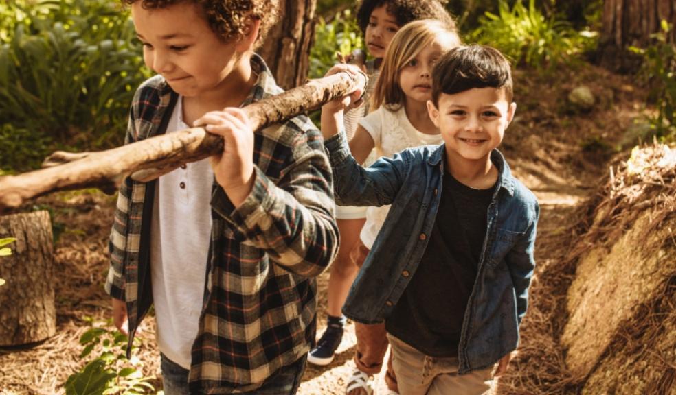 happy children carrying a branch whilst at a nature childrens camp picture of happy children carrying a branch whilst at a nature childrens camp