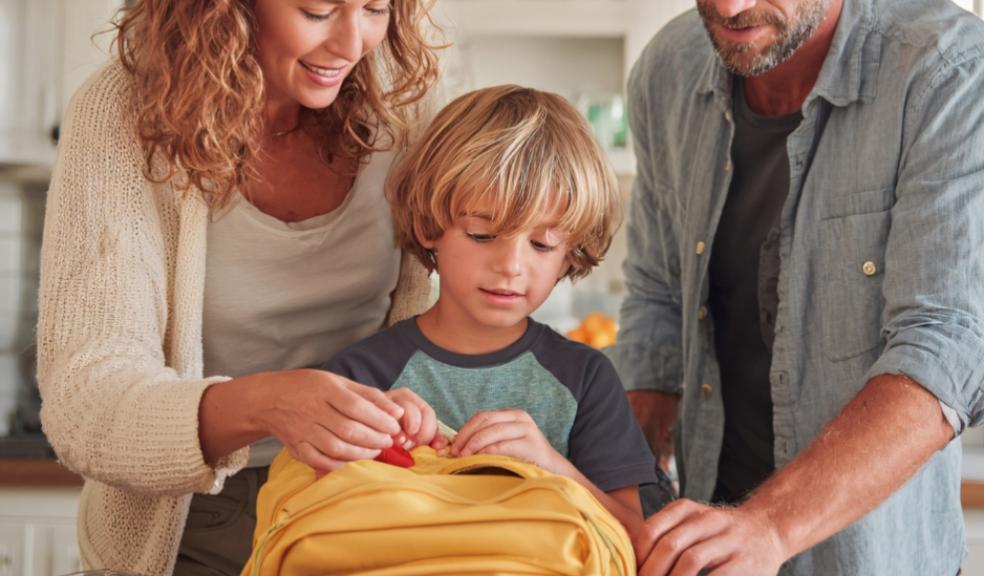 picture of parents helping their child pack their school bag as part of a evening routine