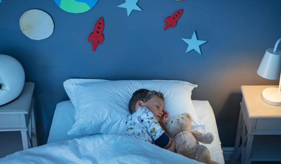 picture of a child asleep in a blue space themed bedroom
