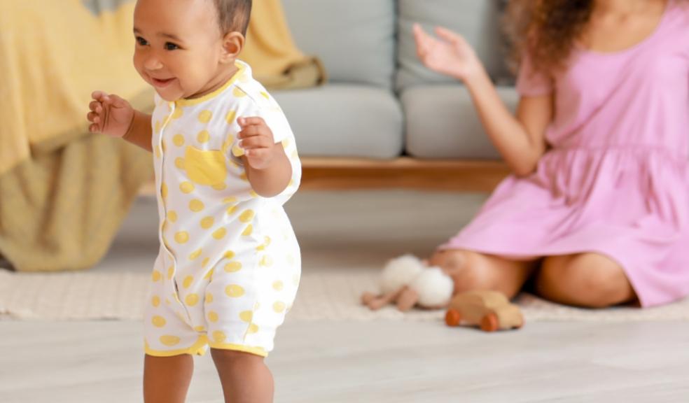 picture of child learning to walk with mum watching