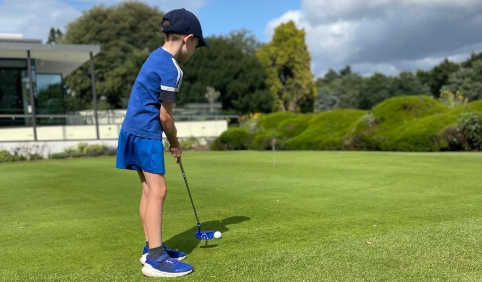 picture of a child playing golf