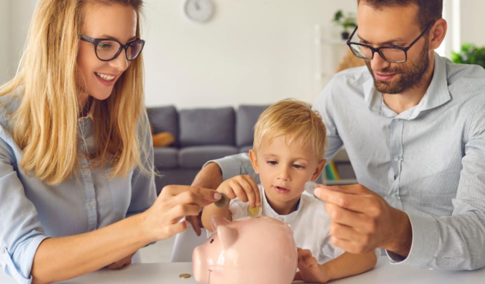 picture of a child putting money into a piggy bank