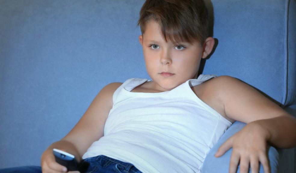 picture of a child sat on a sofa watching television