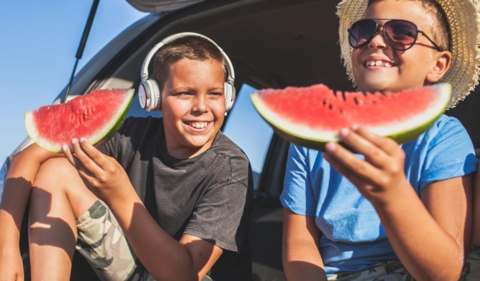picture of children eating watermelon in a car