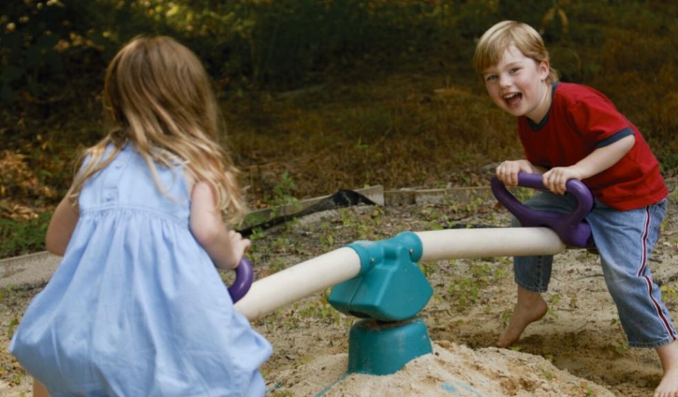 children playing outdoors on a seesaw picture of children playing outdoors on a seesaw