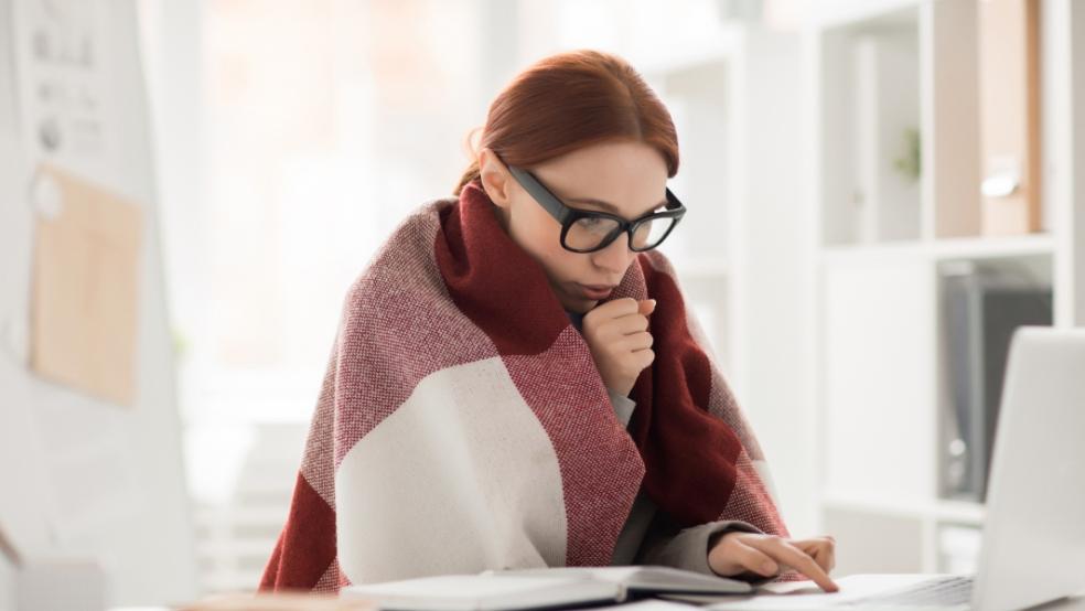 picture of a cold woman working in a blanket