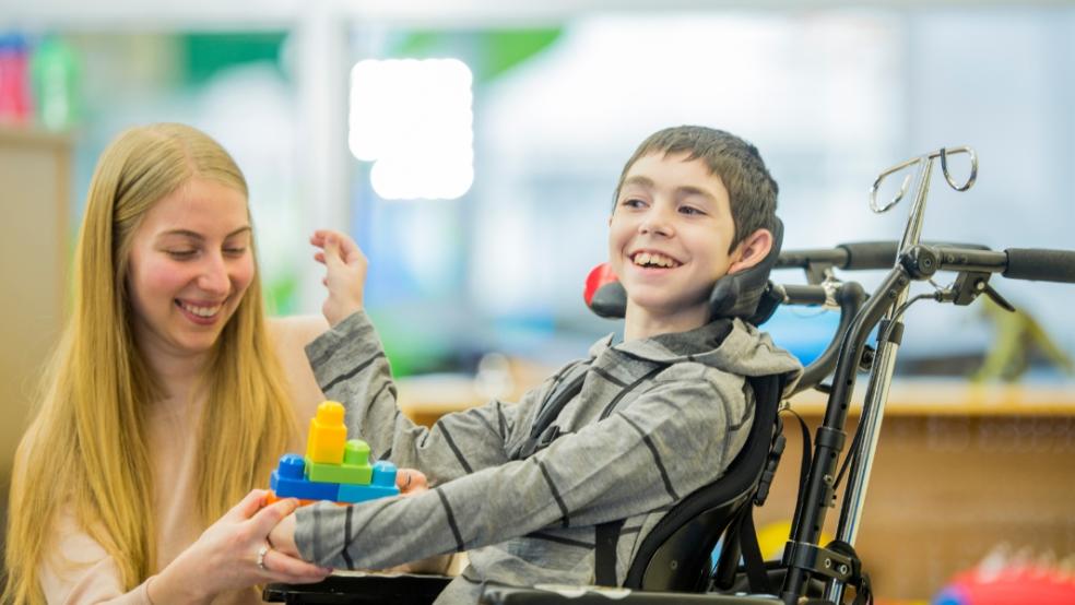 picture of disabled child and carer