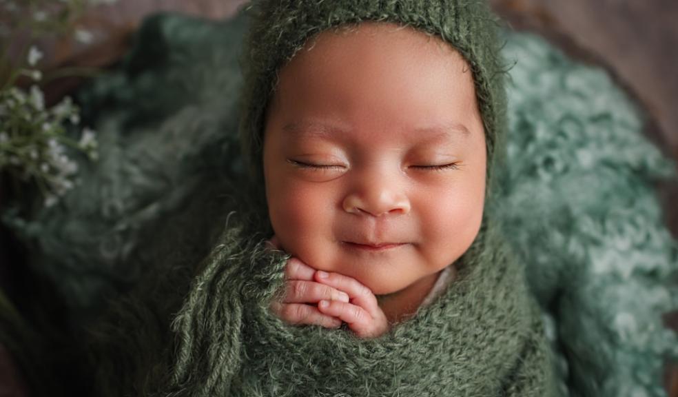 picture of a happy baby wrapped in a green blanket