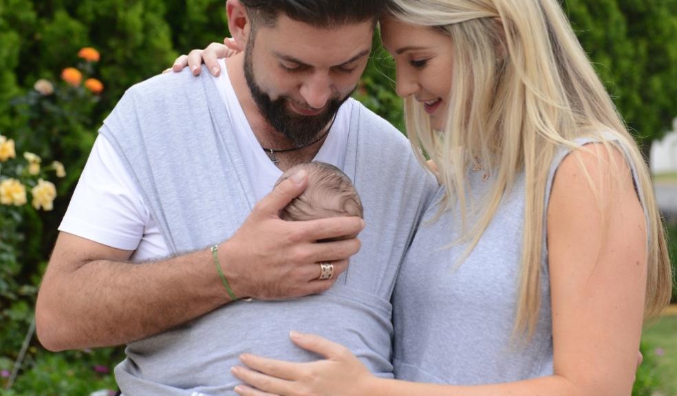 picture of happy couple with baby in a Dreamgeni snuggleroo baby carrier
