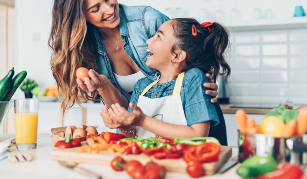 picture of a happy parent and child cooking healthy food