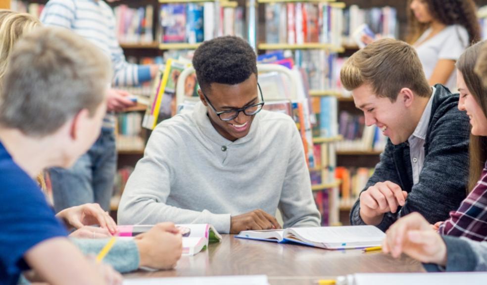 happy teens revising in a library picture of happy teens revising in a library