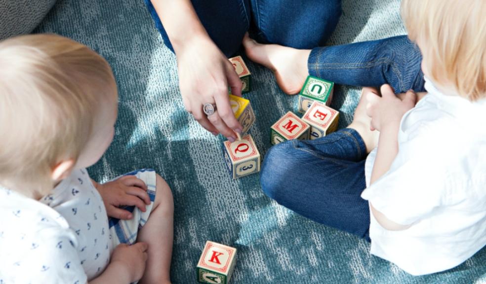 Children sitting down with blocks with letters on