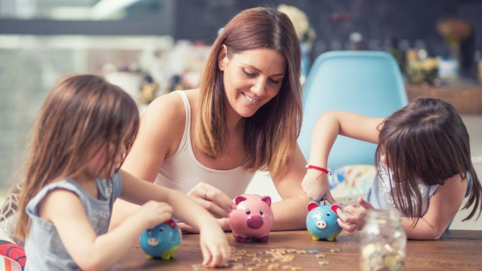 picture of a mum and children putting money in piggy banks