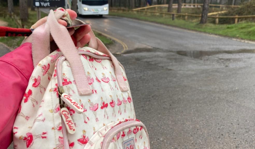 picture of mum holding up a bag in front of a coach