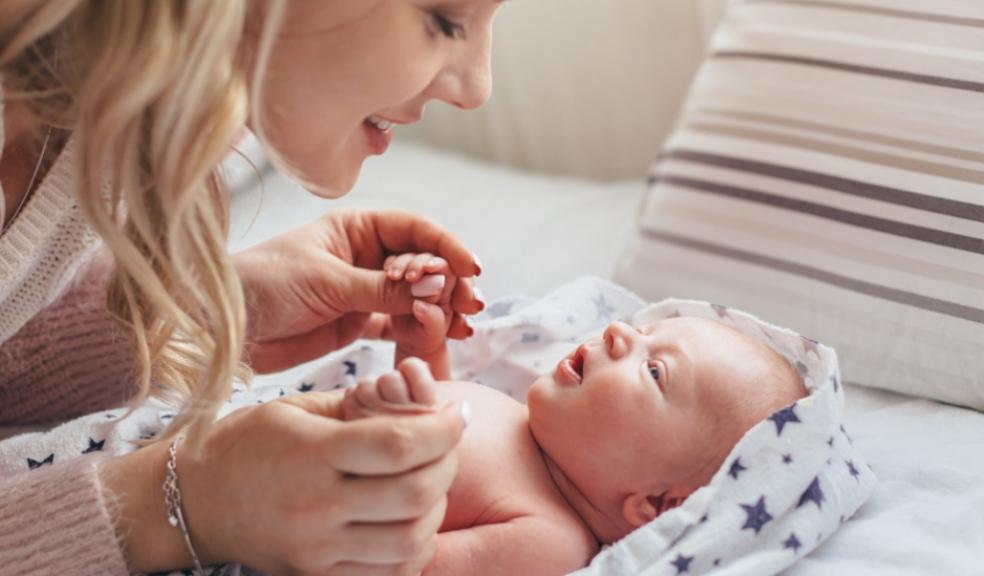 picture of a mum with newborn baby wrapped in a star blanket