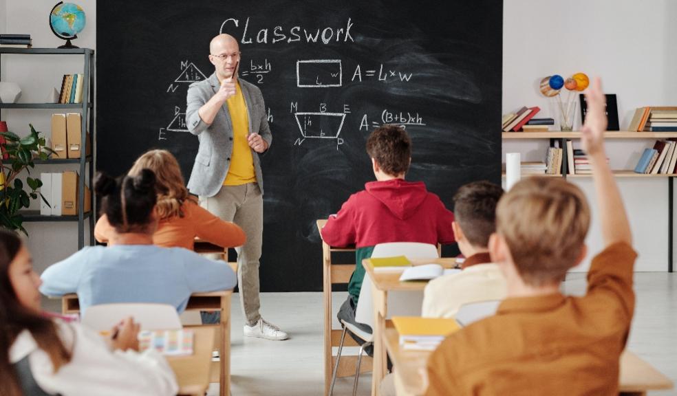 picture of an older, male teacher teaching a classroom of students