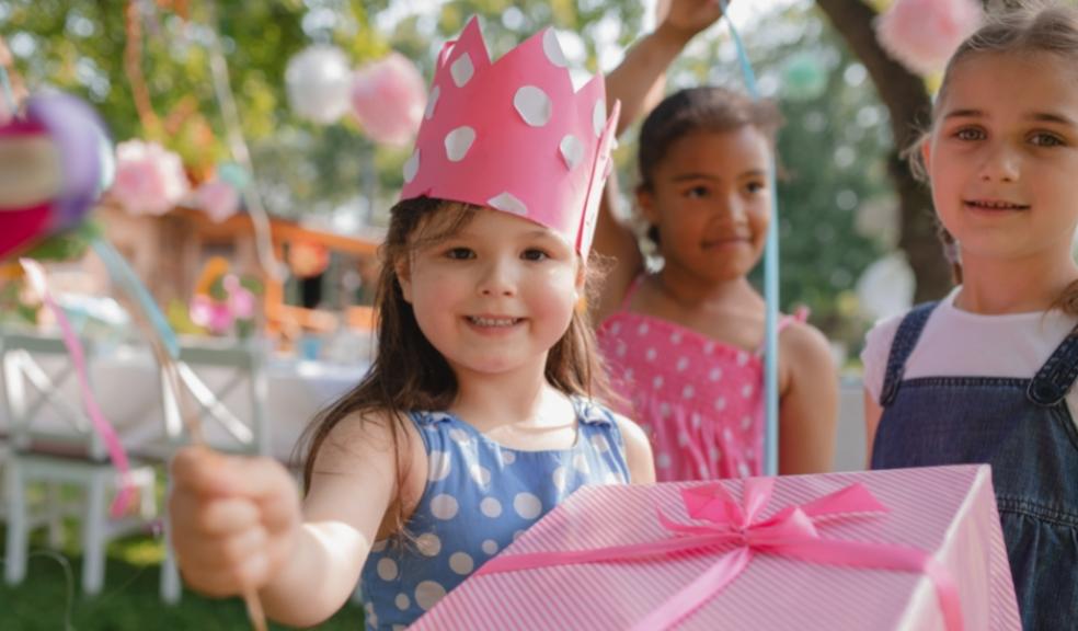 picture of a girl at a birthday party with a party hat and present