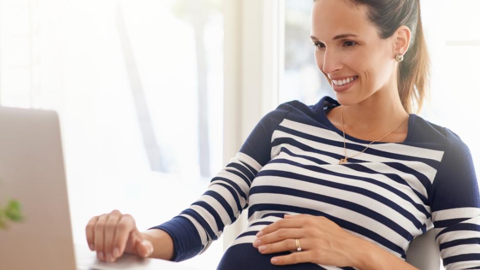 picture of a pregnant person on a laptop