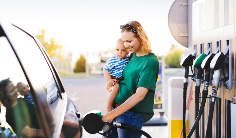 Mum and baby putting petrol in a car at a service station