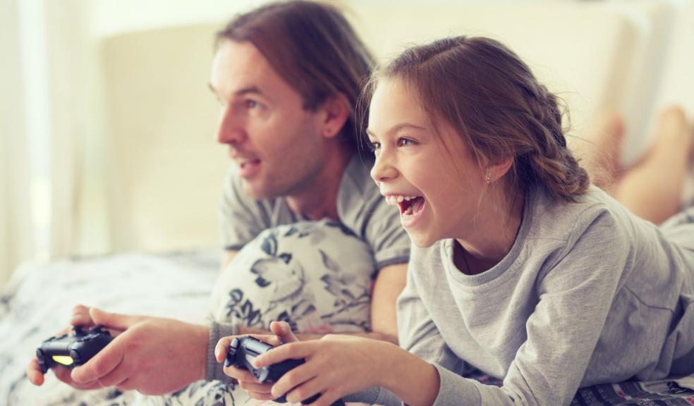 Picture of a child playing video games with her dad