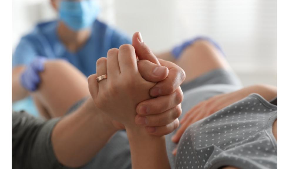 picture of a woman in labour holding someones hand