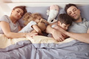 picture of family sleeping in a bed