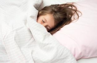 picture of girl asleep in pink and white bed