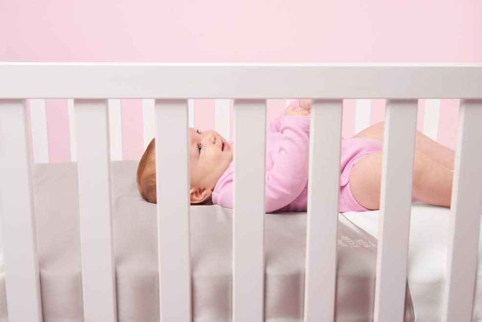 picture of a happy baby in a cot
