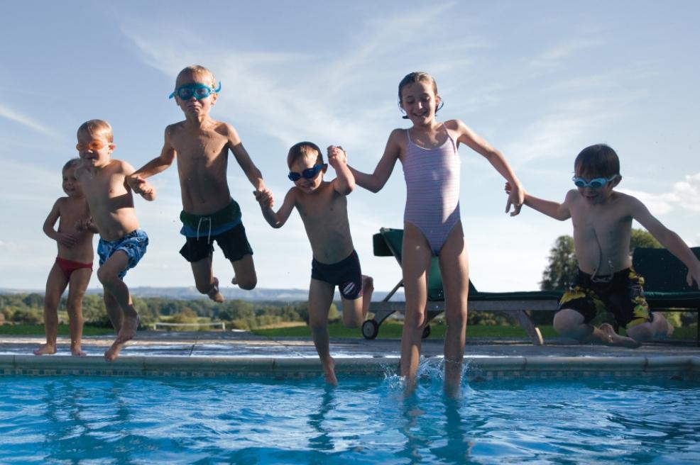 picture of happy children jumping into a swimming pool