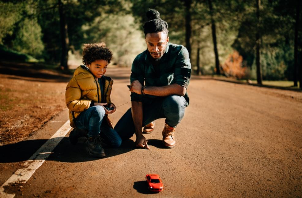 picture of a father and son playing with a remote control car