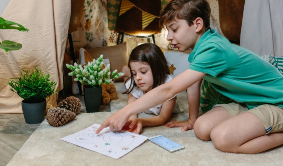 picture of brother and sister planning a treasure hunt at home