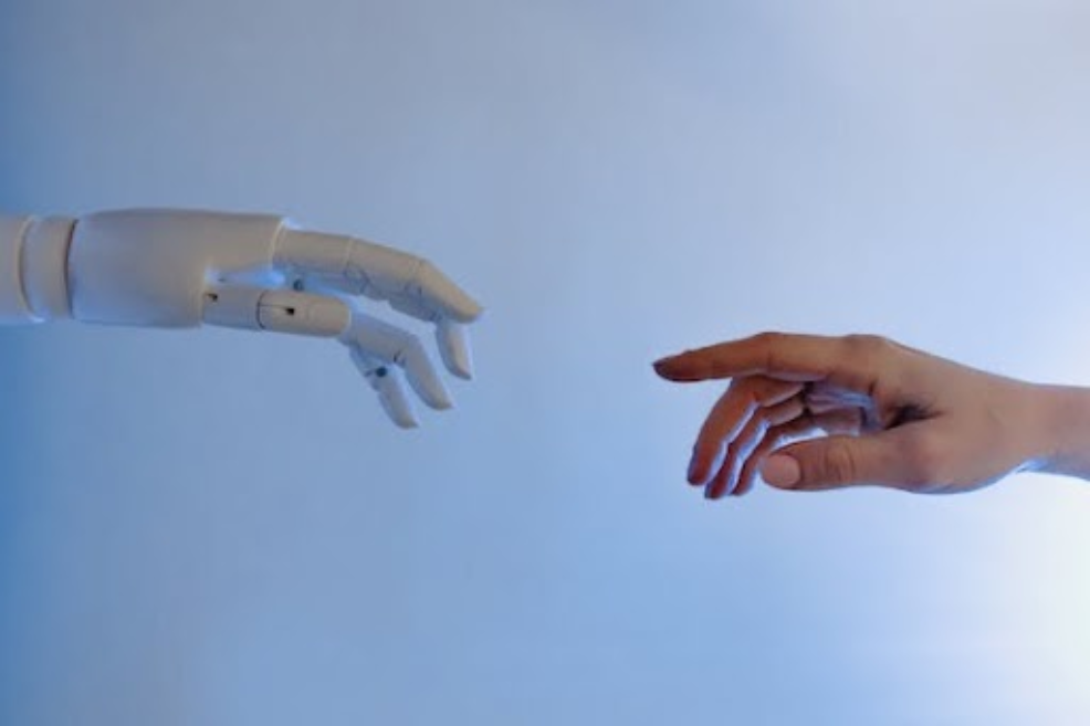 picture of a human hand reaching out to touch a robotic hand