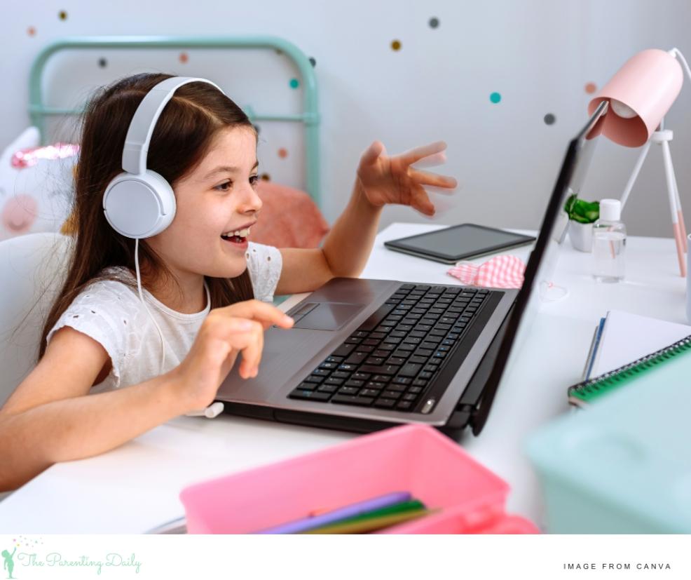 picture of a happy child sat at a desk using a laptop for online learning