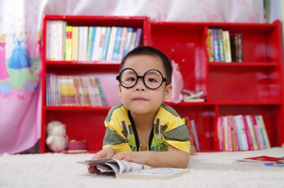 picture of a Child wearing glasses reading a book