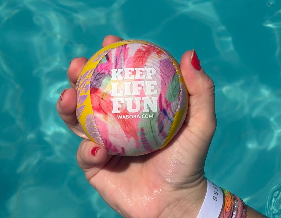 a woman holding a waboba sol beach ball in a swimming pool picture of a woman holding a waboba sol beach ball in a swimming pool