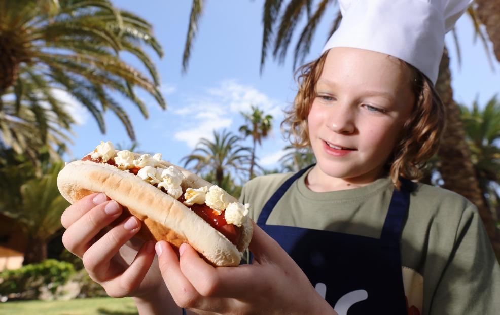 picture of a child eating a hotdog with popcorn on