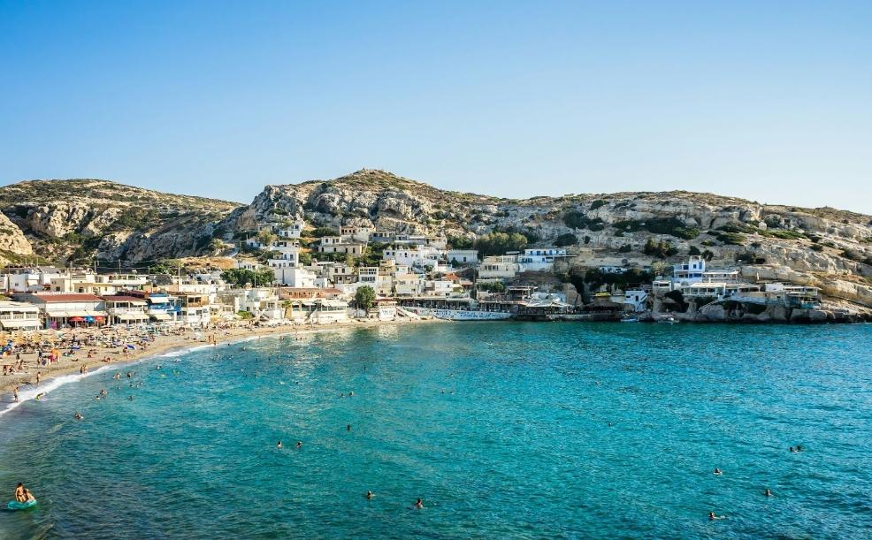 picture of a beach with people swimming in Greece