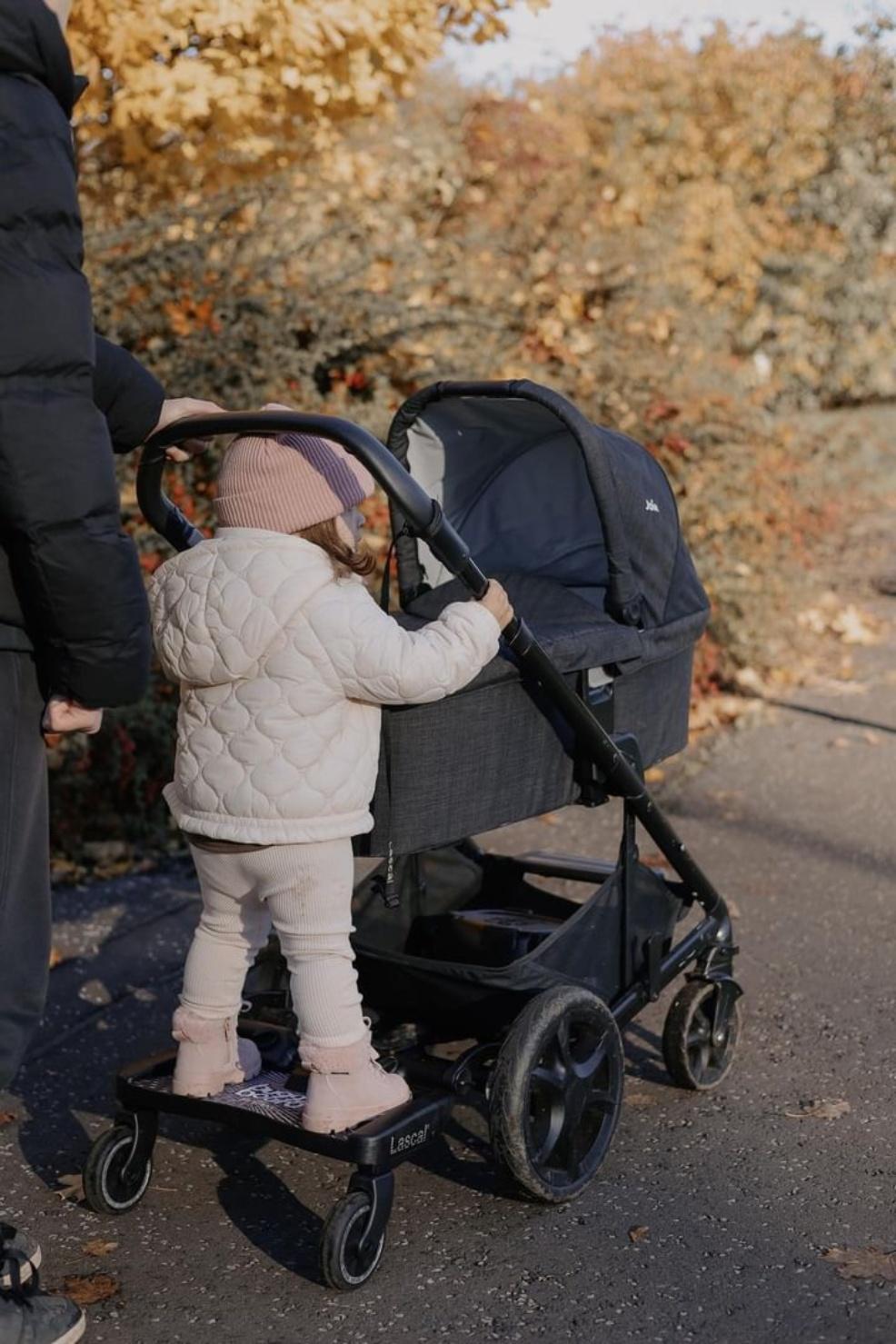 picture of a child using a Lascal buggy board on the back of a pram