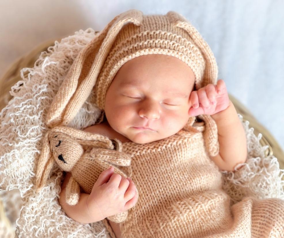 baby in woollen outfit with cuddly toy picture of a baby in woollen outfit with cuddly toy